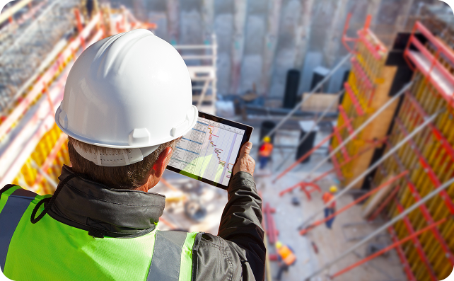 Construction worker reviewing plans at a building site.