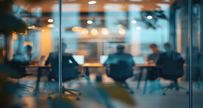 Business team in a modern office, discussing IT strategy and cybersecurity best practices for small businesses, representing proactive IT support.